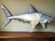 Crafted with a combination of aluminum and capiz shell, this shark wall art measures approximately 1.5 feet in length.