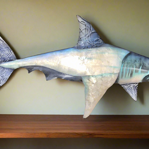 Crafted with a combination of aluminum and capiz shell, this shark wall art measures approximately 1.5 feet in length.