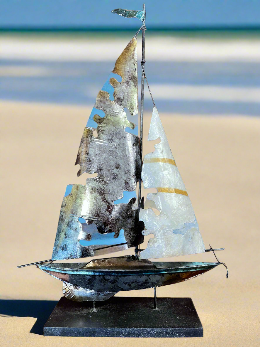 This stunning home decor piece features capiz shell inlay, adding a touch of elegance and coastal charm to any space. The aluminum and capiz shell torn sailboat standing is expertly crafted and perfect for those who appreciate unique and high-quality design. Add a coastal touch to your home with this magnificent piece.18 tall x 13 wide

